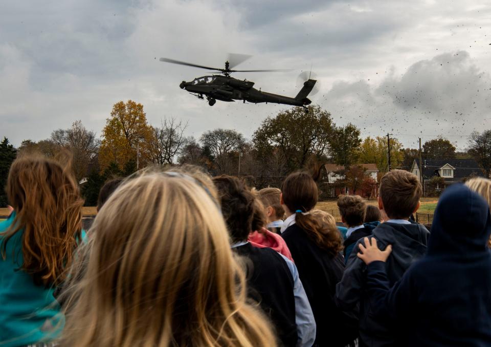 Students at Overbrook Catholic School watch U.S. Army helicopters land in the soccer field at their school as part of a Veterans Day celebration in Nashville, Tenn., Friday, Nov. 10, 2023.