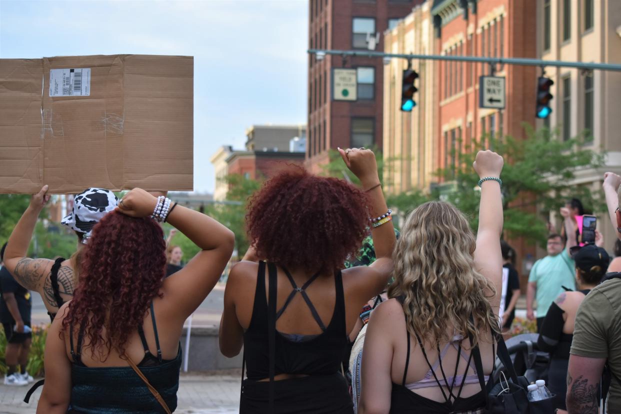 Three protesters raise their fists in solidarity with marginalized communities at the Fourth of July Freedom March in downtown Canton.