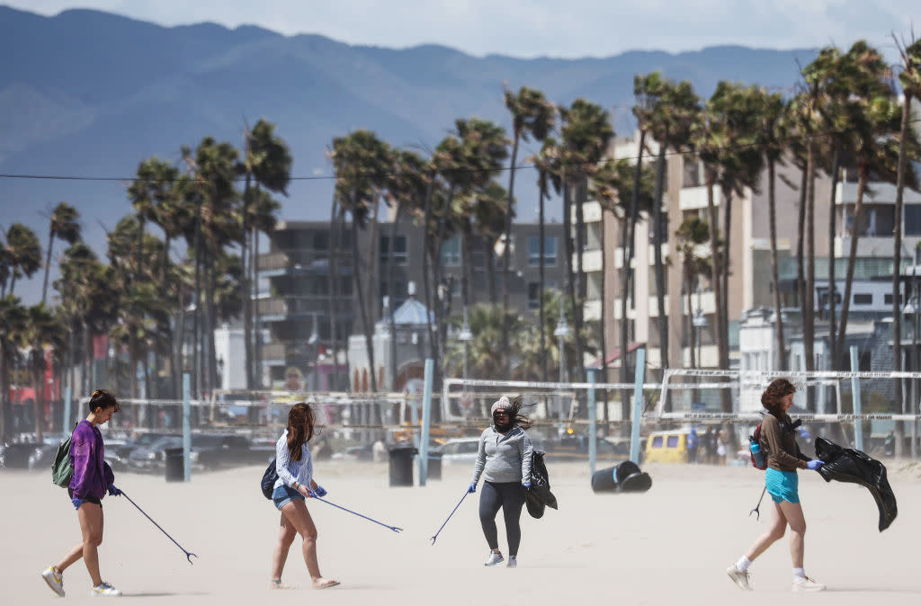  Volunteers pick up litter on a windy Venice Beach as part of an Earth Day cleanup event with the Ecological Servants Project on April 22, 2022 in Venice, California. 