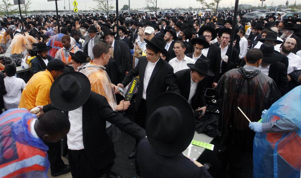 A large crowd of Orthodox Jewish men wait to be checked by security at MetLife stadium in East Rutherford, N.J, Wednesday, Aug. 1, 2012, as they arrive for the start of the celebration Siyum HaShas. The Siyum HaShas, marks the completion of the Daf Yomi, or daily reading and study of one page of the 2,711 page book. The cycle takes about 7½ years to finish. This is the 12th put on by Agudath Israel of America, an Orthodox Jewish organization based in New York. Organizers say this year's will be, by far, the largest one yet. More than 90,000 tickets have been sold, and faithful will gather at about 100 locations worldwide to watch the celebration. (AP Photo/Mel Evans)