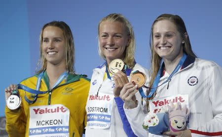 Swimming – 17th FINA World Aquatics Championships – Women's 100m Butterfly awarding ceremony – Budapest, Hungary – July 24, 2017 – (L-R) Emma McKeon (silver) of Australia, Sarah Sjostrom (gold) of Sweden and Kelsi Worrell (bronze) of U.S. pose with the medals. REUTERS/Laszlo Balogh