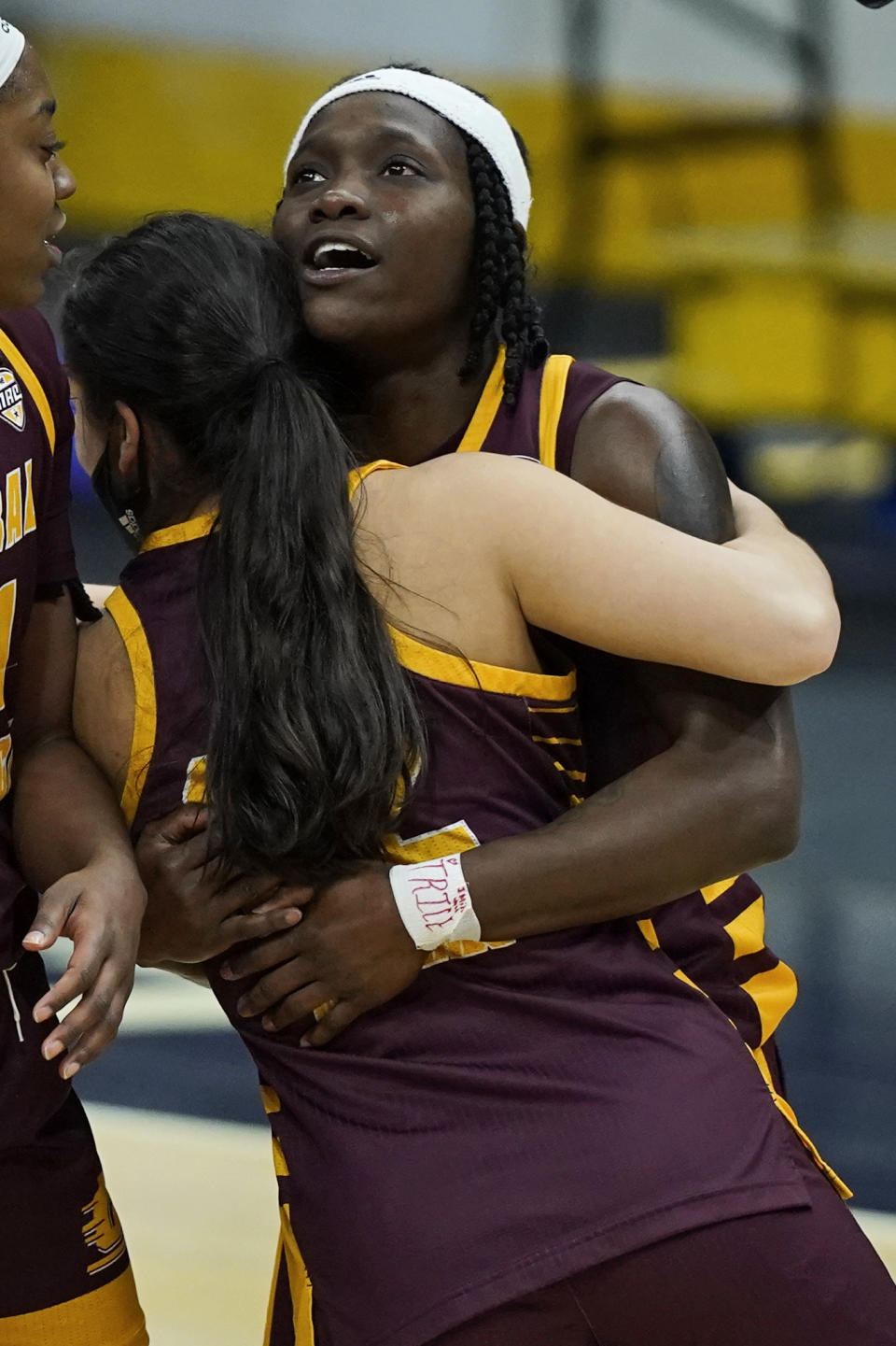 Central Michigan's Micaela Kelly is hugged by a teammate after they defeated Bowling Green 77-72 in an NCAA college basketball game in the championship of the Mid-American Conference tournament, Saturday, March 13, 2021, in Cleveland. (AP Photo/Tony Dejak)