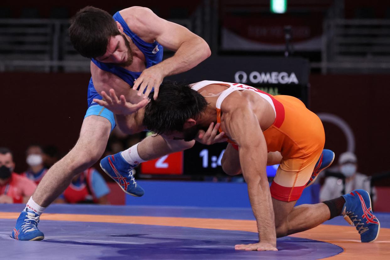 Russia's Zavur Uguev (blue) wrestles India's Kumar Ravi in their men's freestyle 57kg wrestling final match during the Tokyo 2020 Olympic Games at the Makuhari Messe in Tokyo on August 5, 2021. (Photo by Jack GUEZ / AFP) (Photo by JACK GUEZ/AFP via Getty Images)