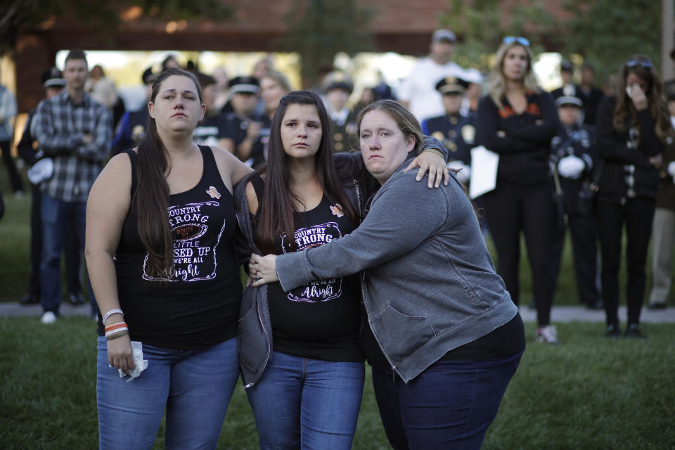 From left, Ashely Ivey, Amber Ivey and Amber Poole comfort each other during a ceremony Tuesday, Oct. 1, 2019, on the anniversary of the mass shooting two years earlier in, Las Vegas. (AP Photo/John Locher)