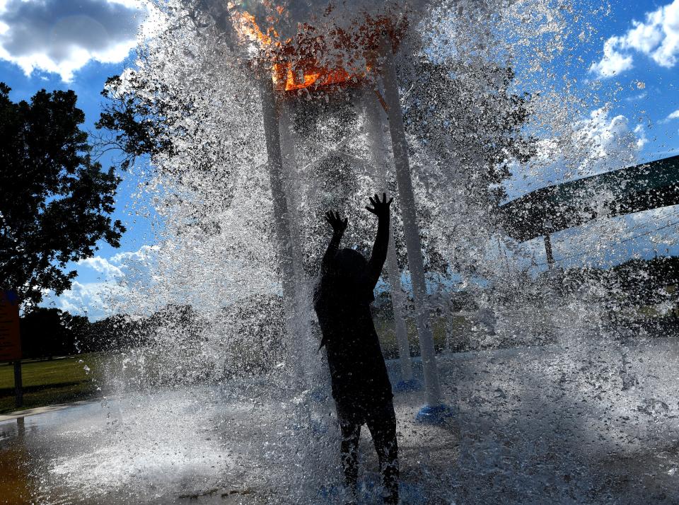 Paizly Lopez, 7, raises her hands against the water as the bucket drops on her at the Stevenson Park Splash Pad July 21, 2020. City officials were notified Friday by the third-party company managing Abilene's splash pads that there will be a delay in opening them for the summer due to ongoing repairs.