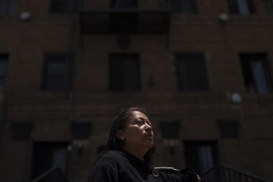 Deneffy Sánchez's mother, Lilian Lopez, stands outside an apartment building where she and her two children share a studio apartment with a roommate, in Los Angeles, Saturday, June 24, 2023. Pandemic job loss coupled with rising rents have pushed many California residents like Lopez and her family into desperate housing arrangements. (AP Photo/Jae C. Hong)