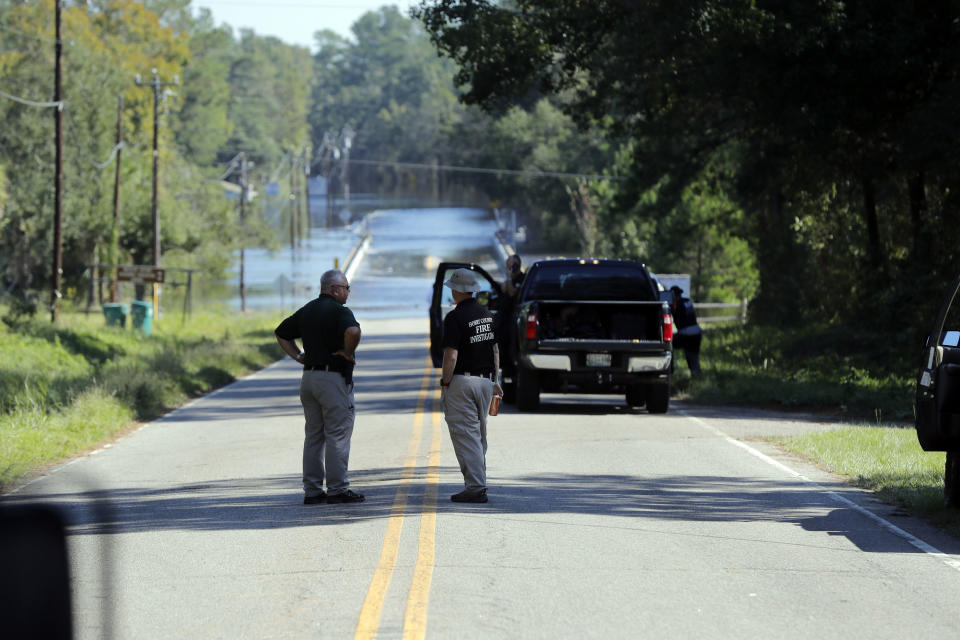 Responders congregate Wednesday, Sept. 19, 2018 near where two people drowned Tuesday evening when they were trapped in a Horry County Sheriff transport van while crossing an overtopped bridge over the Little Pee Dee River on Hwy 76, during rising floodwaters in the aftermath of Hurricane Florence in Marion County, S.C. (AP Photo/Gerald Herbert)