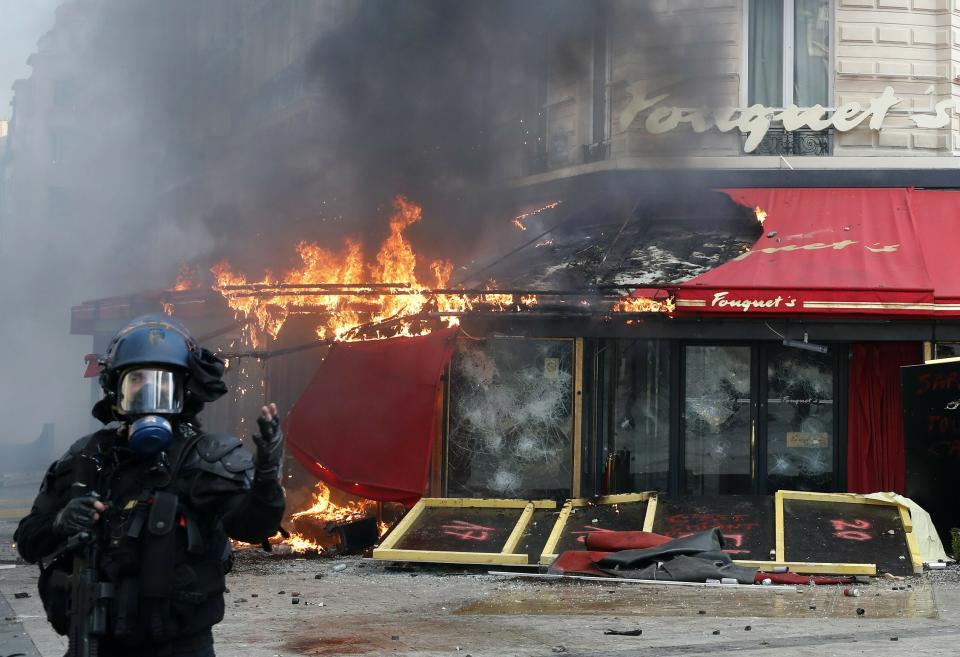 Paris famed restaurant Fouquet's burns on the Champs Elysees avenue during a yellow vests demonstration Saturday, March 16, 2019 in Paris. Paris police say more than 100 people have been arrested amid rioting in the French capital by yellow vest protesters and clashes with police. They set life-threatening fires, smashed up luxury stores and clashed with police firing tear gas and water cannon (AP Photo/Christophe Ena)