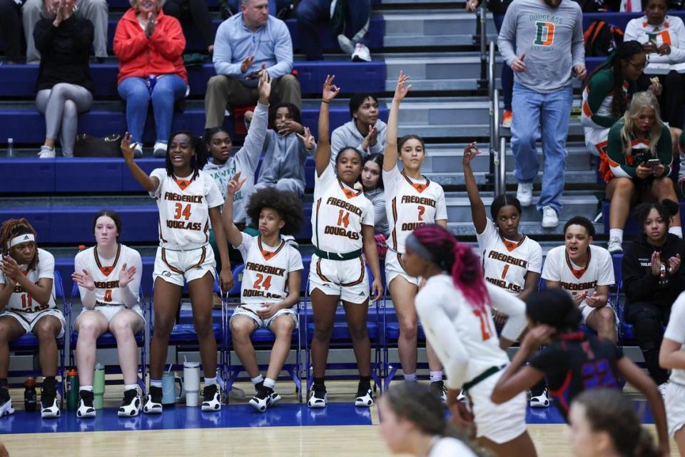 The Frederick Douglass bench celebrates a teammate scoring against Scott County during the 42nd District Tournament semifinals at Henry Clay High School on Tuesday.