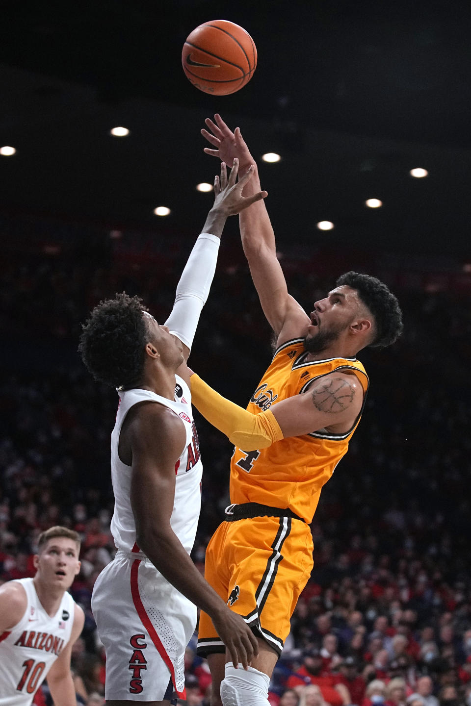 Wyoming guard Hunter Maldonado, right, shoots over Arizona guard Justin Kier during the first half of an NCAA college basketball game Wednesday, Dec. 8, 2021, in Tucson, Ariz. (AP Photo/Rick Scuteri)