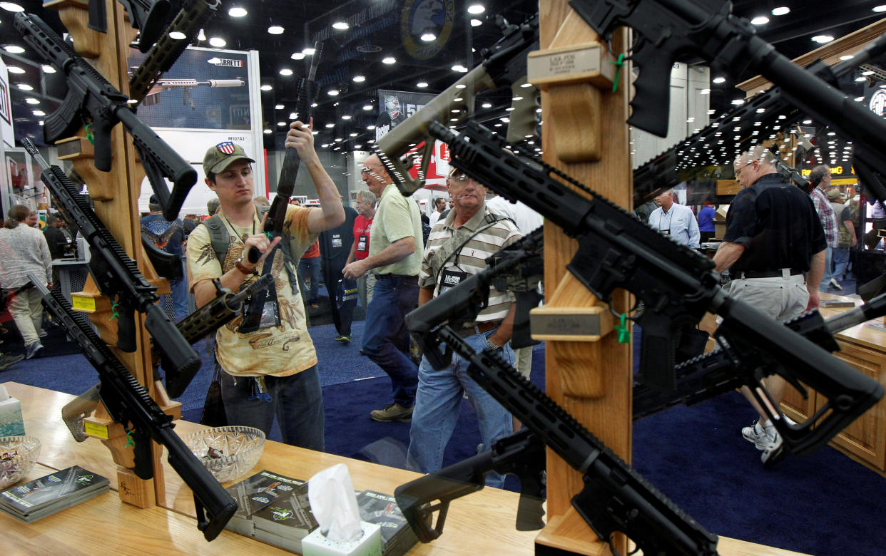 Gun enthusiasts look over Rock River Arms' guns at the National Rifle Association's annual meetings and exhibits show in Louisville, Kentucky, on May 21, 2016.&nbsp; (Photo: John Sommers II / Reuters)