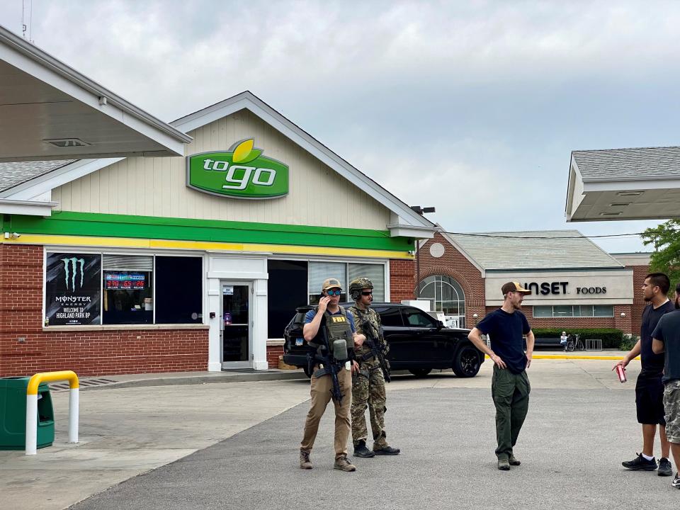 Members of the FBI gather at a BP gas station in Highland Park, Ill., on July 4.