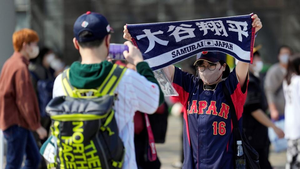 日本球迷在場外高舉印有大谷翔平的毛巾。（圖／AP NEWSROOM）