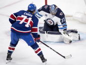 Winnipeg Jets goaltender Connor Hellebuyck stops Montreal Canadiens' Jake Evans during second-period NHL hockey game action in Montreal, Saturday, April 10, 2021. (Graham Hughes/The Canadian Press via AP)