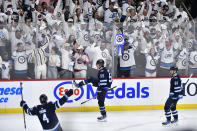 Winnipeg Jets' Mark Scheifele (55) celebrates his goal against the Colorado Avalanche with Neal Pionk (4) and Kyle Connor (81) during the second period in Game 2 of an NHL hockey Stanley Cup first-round playoff series Tuesday, April 23, 2024, in Winnipeg, Manitoba. (Fred Greenslade/The Canadian Press via AP)