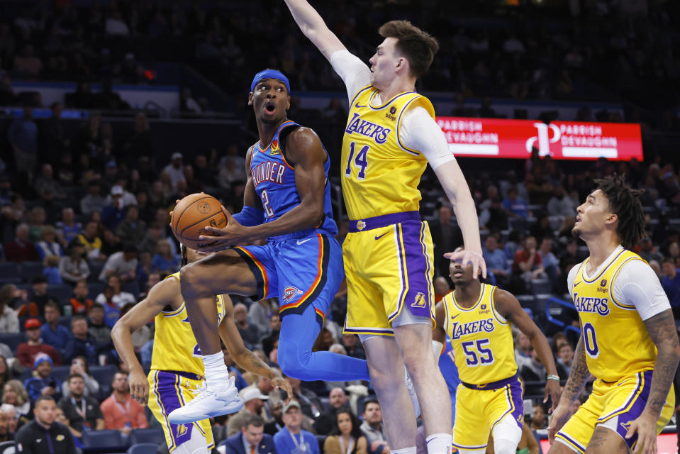 FILE - Oklahoma City Thunder guard Shai Gilgeous-Alexander (2) prepares to pass the ball away from Los Angeles Lakers center Colin Castleton (14) as Lakers guard Jalen Hood-Schifino, right, watches during the second half of an NBA basketball game Nov. 30, 2023, in Oklahoma City. Oklahoma City voters will decide Tuesday Dec. 12, 2023, whether to approve a 1% sales tax for six years to fund a new downtown arena for the NBA's Oklahoma Thunder. (AP Photo/Nate Billings, File)