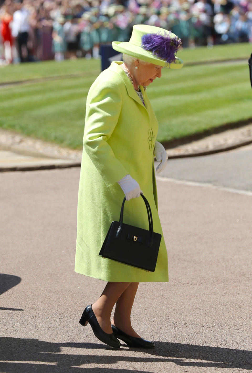 <p>It was bright and bold for the Queen, who arrived shortly before the bride in a lime and purple outfit. Photo: Getty </p>