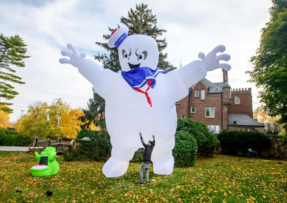 Ryan Wyss, head technician with Prospect Sound and Lighting, wrestles with a giant inflatable Stay Puft Marshmallow Man on Thursday, Oct. 27, 2022 outside the castle on Grandview Drive. The Soderstrom family, who own the castle, with help from members of Peoria Players Theater, are continuing their Halloween tradition. This year's theme is "Ghostbusters."