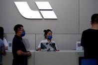 People stand near the logo of Chinese EV maker Li Auto at a product launch event in Beijing