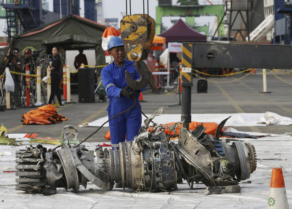 Officials move an engine recovered from the crashed Lion Air jet for further investigation in Jakarta, Indonesia, Sunday, Nov. 4, 2018. The brand new Boeing 737 MAX 8 jet plunged into the Java Sea just minutes after takeoff from Jakarta early on Oct. 29, killing all of its passengers on board. (AP Photo/Achmad Ibrahim)