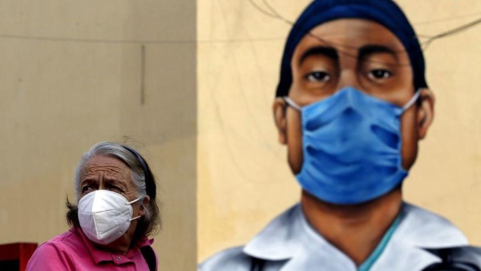 Una mujer con mascarilla frente a un mural en homenaje a los trabajadores de salud en Zapopán, México, el 12 de agosto de 2020.