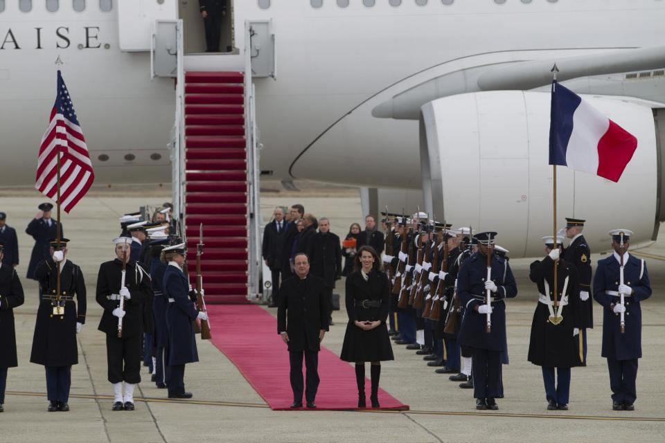 ** CORRECTS THAT JONES IS ACTING CHIEF OF PROTOCOL ** French President Francois Hollande, accompanied by U.S. Acting Chief of Protocol Natalie Jones, listen to the national anthem upon his arrival at Andrews Air Force Base, Md., Monday Feb. 10, 2014, for a three-day visit to U.S. ( AP Photo/Jose Luis Magana)