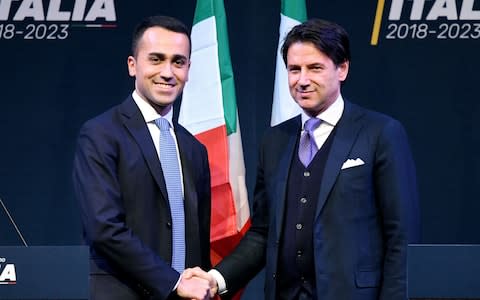 The leader of Italy's populist Five Star Movement, Luigi Di Maio (Left), shakes hands with Italian lawyer Giuseppe Conte - Credit: AFP