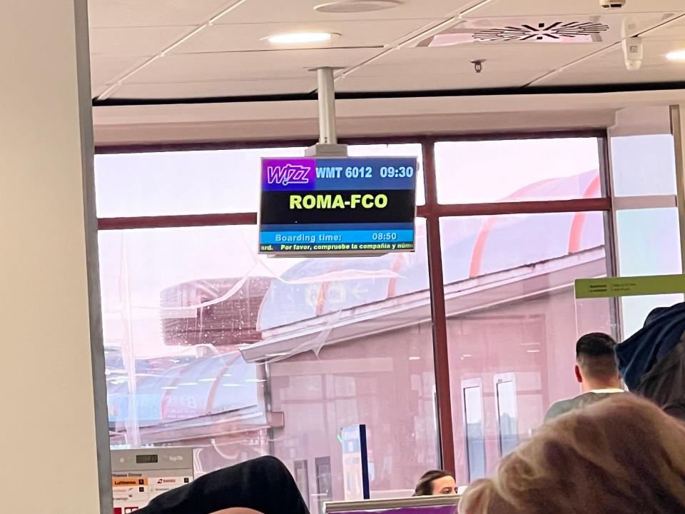 A boarding screen for Roma-Fco displayed for a Wizz flight at Madrid Airport.