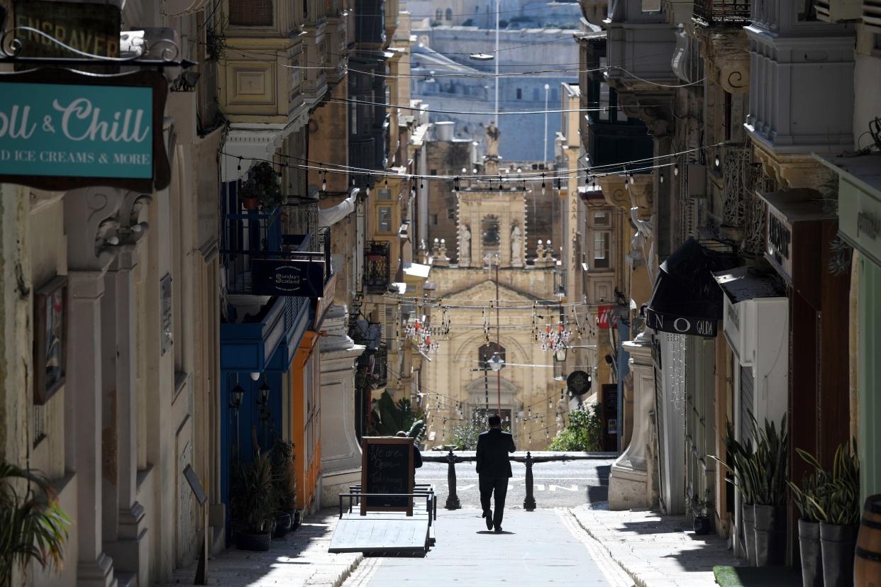 VALLETTA, March 11, 2021 -- A man walks on an empty street in Valletta, Malta, March 11, 2021. The Maltese government on Wednesday announced the closure of schools and non-essential shops in response to a spike in new COVID-19 cases, almost two-thirds of which are attributable to the variant first reported in the UK. The new measures, which will be in force until April 11, include the closure of all non-essential shops and those providing non-essential services such as hairdressers and beauticians while the limitation of group gatherings in public down to a maximum of four people. (Photo by Jonathan Borg/Xinhua via Getty) (Xinhua/Jonathan Borg via Getty Images)