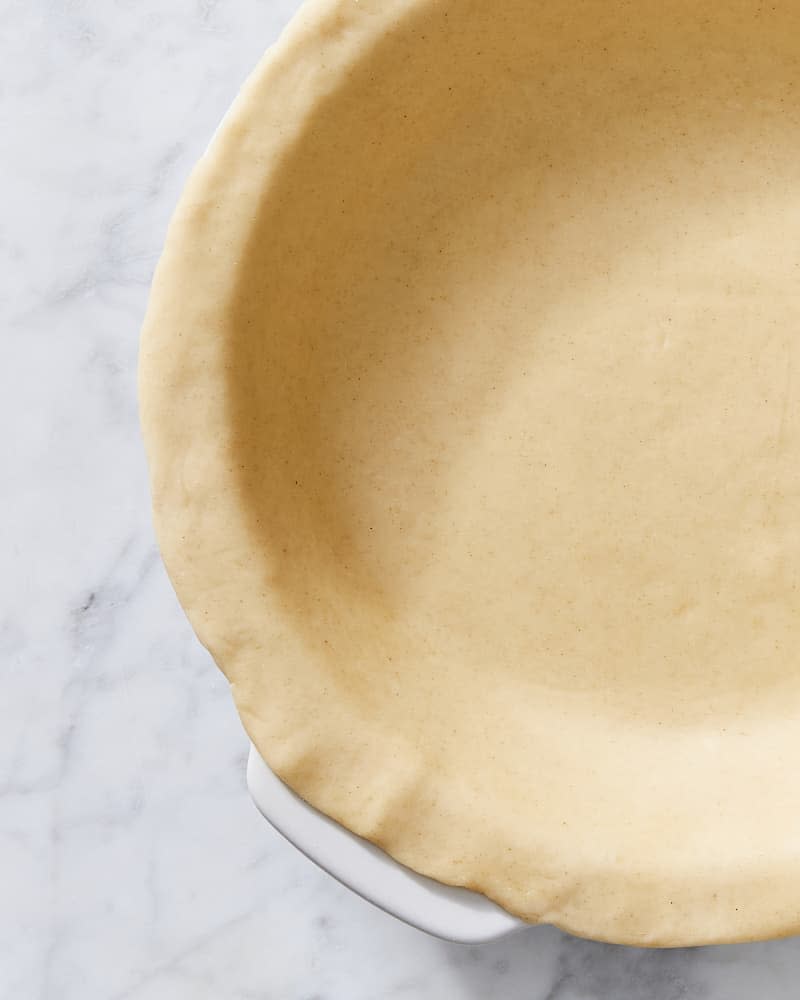 Pie crust in dish ready to be crimped