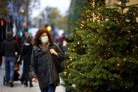 FILE PHOTO: A woman walks past Christmas trees on Oxford Street, amid the coronavirus disease (COVID-19) outbreak, in London