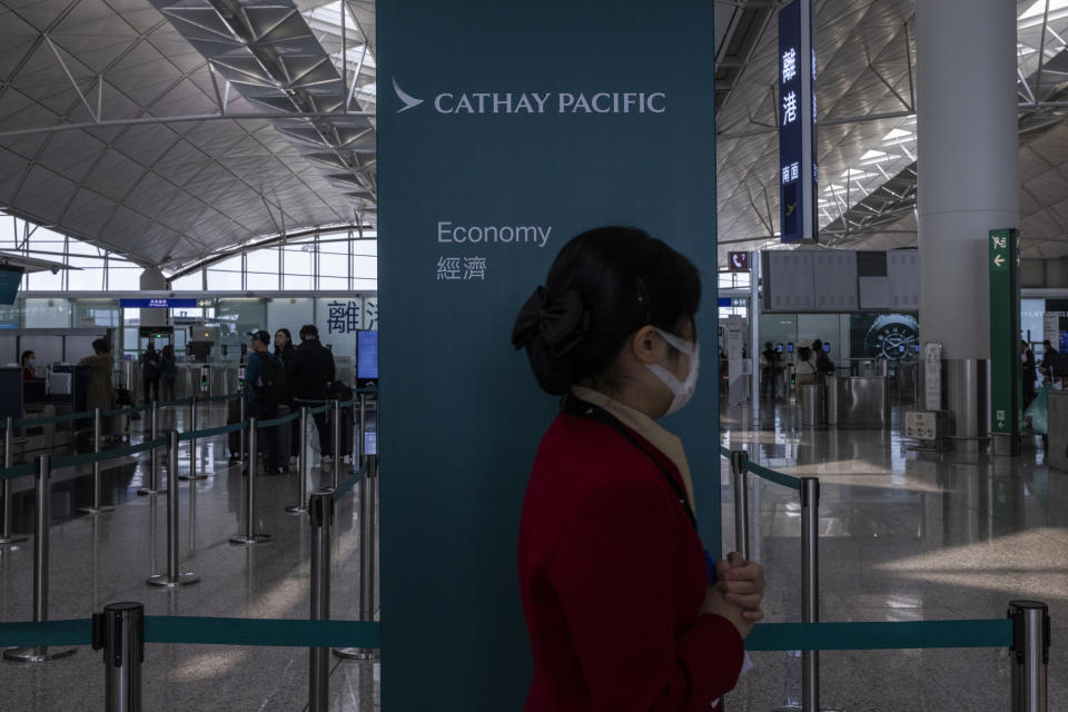 A Cathay Pacific Airways employee walks through the departures hall of Hong Kong International Airport in Hong Kong, on Wednesday, March. 8, 2023. Cathay Pacific Airways Ltd. said it was ready to rebuild as Hong Kong opened up to global visitors, despite reporting wider losses in 2022. (AP Photo/Louise Delmotte)