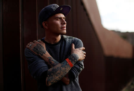 FILE PHOTO: Juan Francisco Cruz, a migrant from Honduras, part of a caravan of thousands traveling from Central America en route to the United States, poses in front of the border wall between the U.S. and Mexico in Tijuana, Mexico, November 24, 2018. REUTERS/Kim Kyung-Hoon