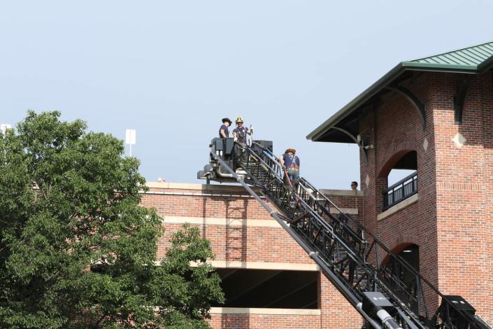 Wichita firefighters were hoisted to the top floor of the Old Town parking garage after two people were found dead inside a car. 