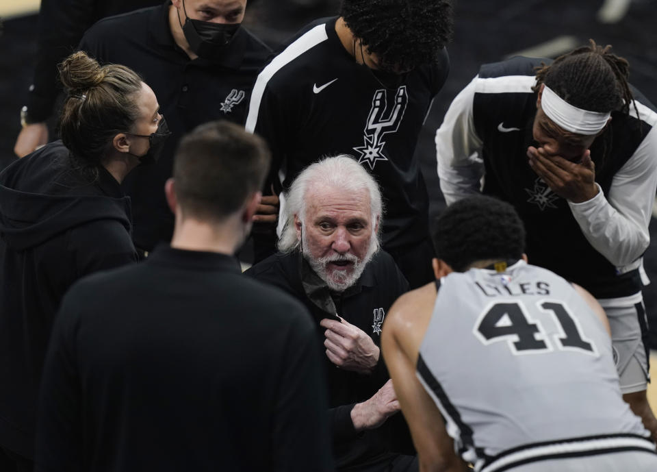 San Antonio Spurs head coach Gregg Popovich, center, talks with his team during the second half of an NBA basketball game against the Oklahoma City Thunder in San Antonio, Thursday, March 4, 2021. (AP Photo/Eric Gay)