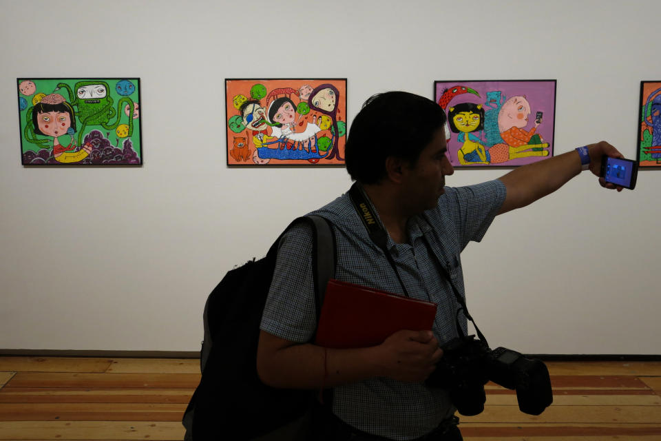 Un periodista se toma una selfie en la exposición "Gestos" de Mon Laferte en el Museo de la Ciudad de México el miércoles 11 de marzo de 2020. Se trata de la primera exposición de arte de Laferte. Cerca de 70 obras con varias técnicas entre tinta, óleo y acrílico se presentarán del 12 de marzo al 12 de abril en la muestra. (Foto AP/Berenice Bautista)