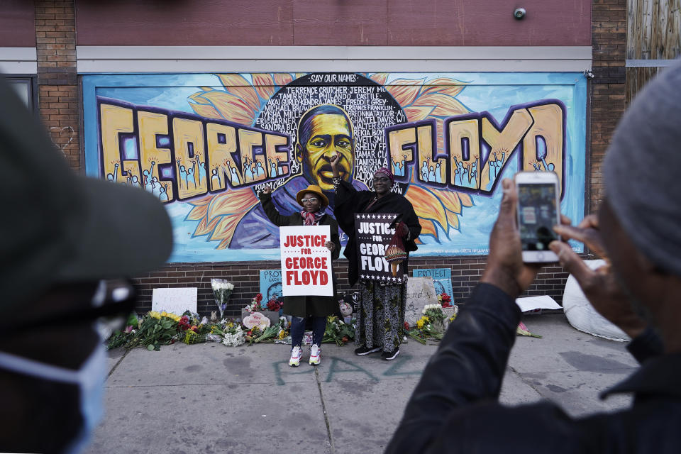 People pose for pictures in front of a mural for George Floyd after a guilty verdict was announced at the trial of former Minneapolis police Officer Derek Chauvin for the 2020 death of Floyd, Tuesday, April 20, 2021, in Minneapolis, Minn. (AP Photo/Morry Gash)