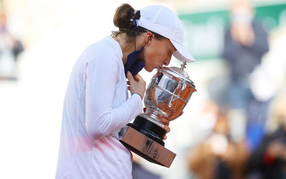 Iga Swiatek kisses the trophy after winning the French Open - Getty Images