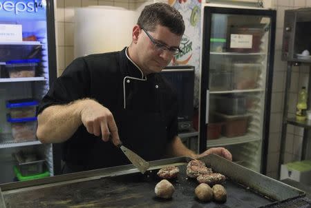 A chef prepares "Kibbeh", also known as Syrian meatballs, in the kitchen of the Castro restaurant in Budapest, Hungary, September 29, 2015. REUTERS/Bernadett Szabo