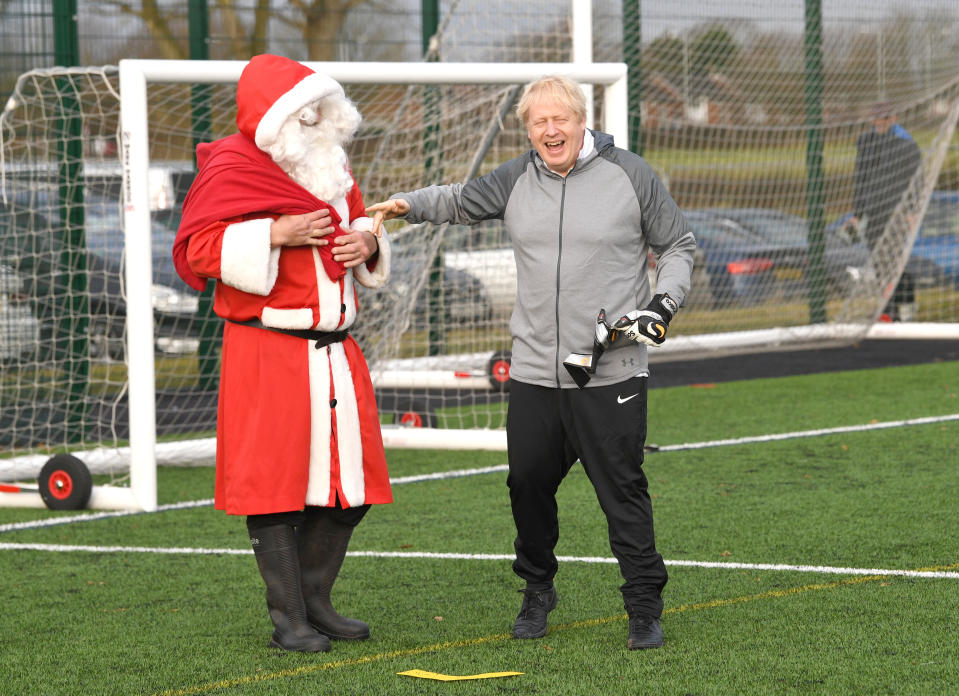 Prime Minister Boris Johnson with a man dressed as Father Christmas before a football match between Hazel Grove Utd and Poynton Jnr u10s in the Cheshire Girls football league in Cheadle Hume, Cheshire, while on the election campaign trail.