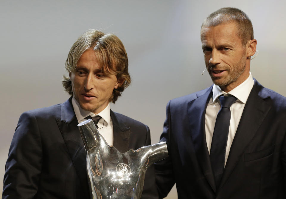 Luka Modric holds his UEFA Men's Player of the Year trophy as he stands next to UEFA President Aleksander Ceferin during the UEFA Champions League draw at the Grimaldi Forum, in Monaco, Thursday, Aug. 30, 2018. (AP Photo/Claude Paris)