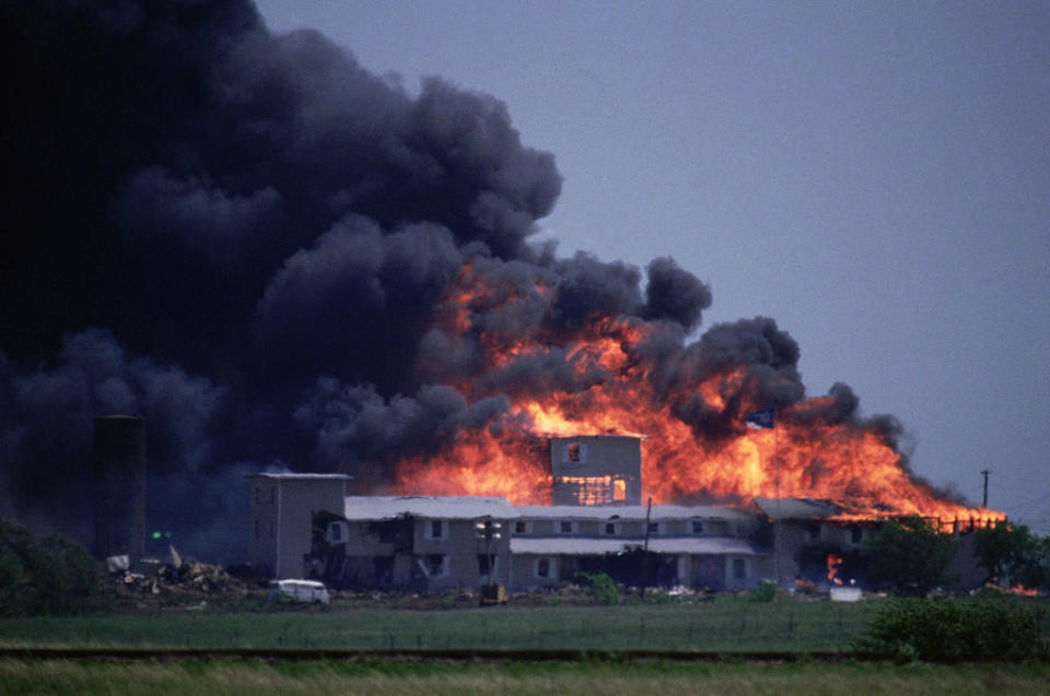 Large fire and smoke engulfing an industrial building in the distance