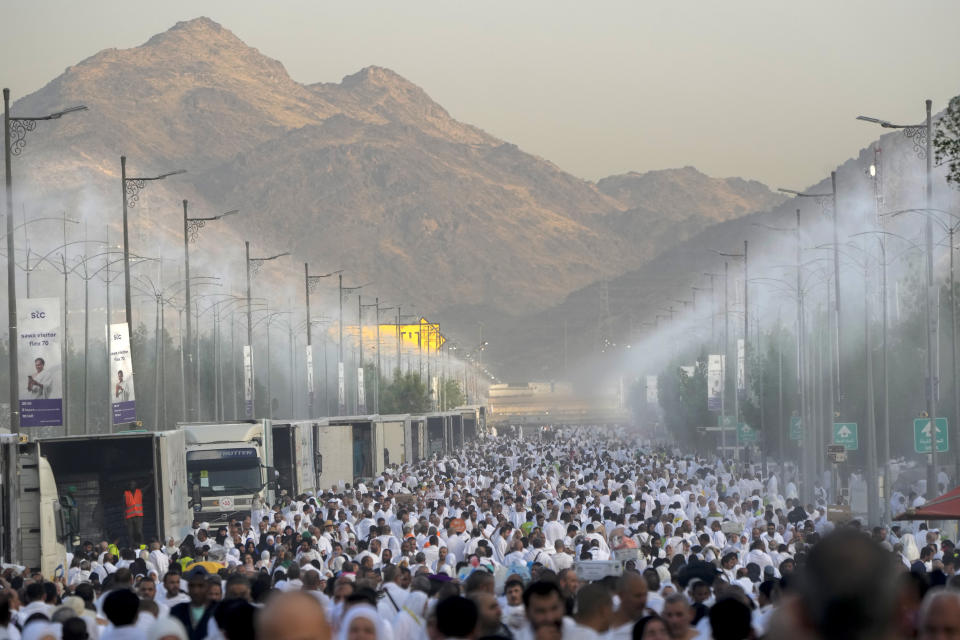 Water mist is sprayed on Muslim pilgrims as they walk towards the rocky hill known as the Mountain of Mercy, on the Plain of Arafat, during the annual Hajj pilgrimage, near the holy city of Mecca, Saudi Arabia, Tuesday, June 27, 2023. Around two million pilgrims are converging on Saudi Arabia's holy city of Mecca for the largest Hajj since the coronavirus pandemic severely curtailed access to one of Islam's five pillars. (AP Photo/Amr Nabil)