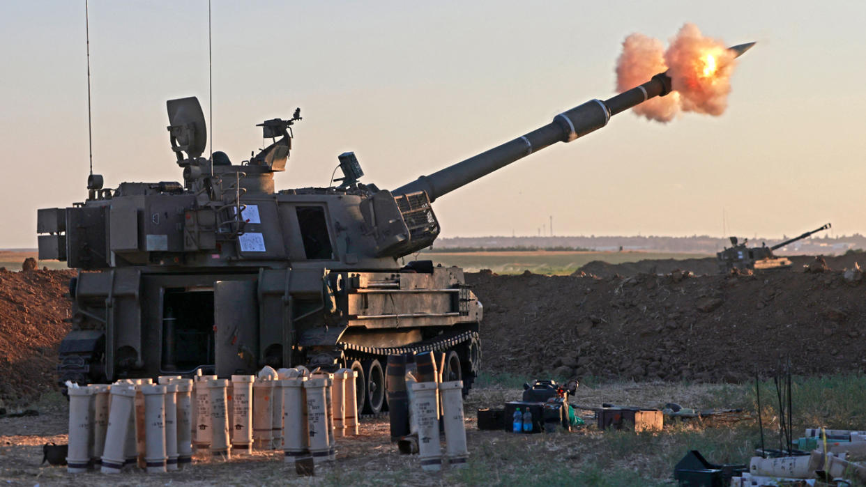 Israeli soldiers fire a 155mm self-propelled howitzer towards the Gaza Strip from their position along the border, on May 18, 2021. (Menahem Kahana/AFP via Getty Images)