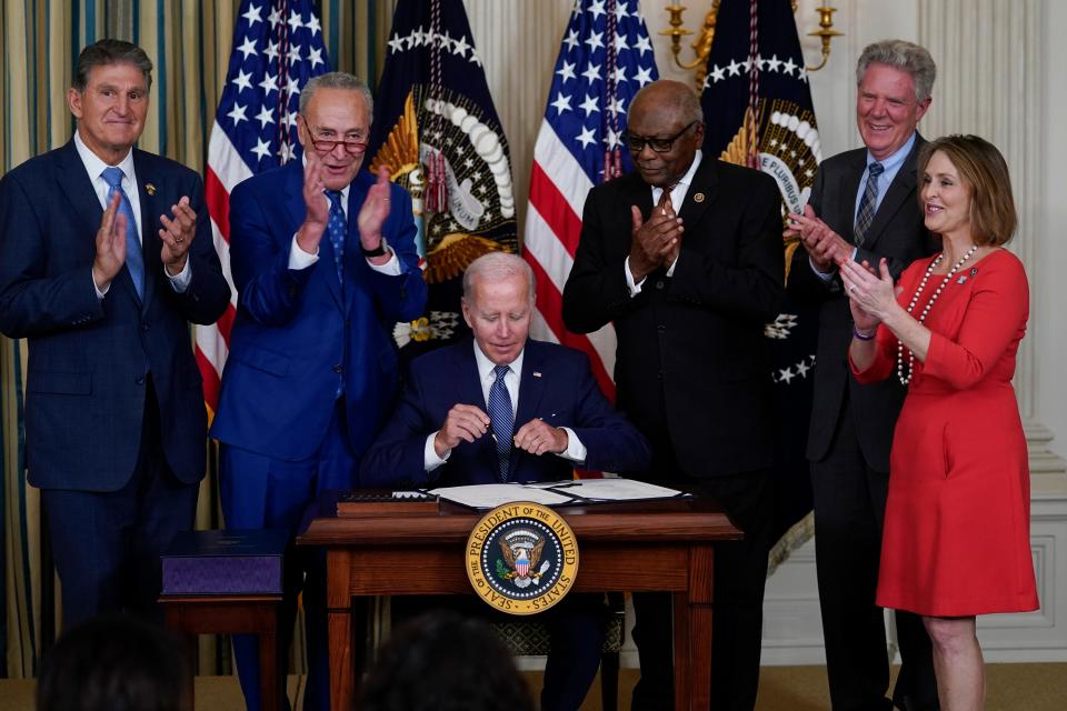 President Joe Biden signs the Democrats' landmark climate change and health care bill in the State Dining Room of the White House in Washington on Tuesday, as from left, Sen. Joe Manchin, D-W.Va., Senate Majority Leader Chuck Schumer of N.Y., House Majority Whip Rep. James Clyburn, D-S.C., Rep. Frank Pallone, D-N.J., and Rep. Kathy Castor, D-Fla., watch.