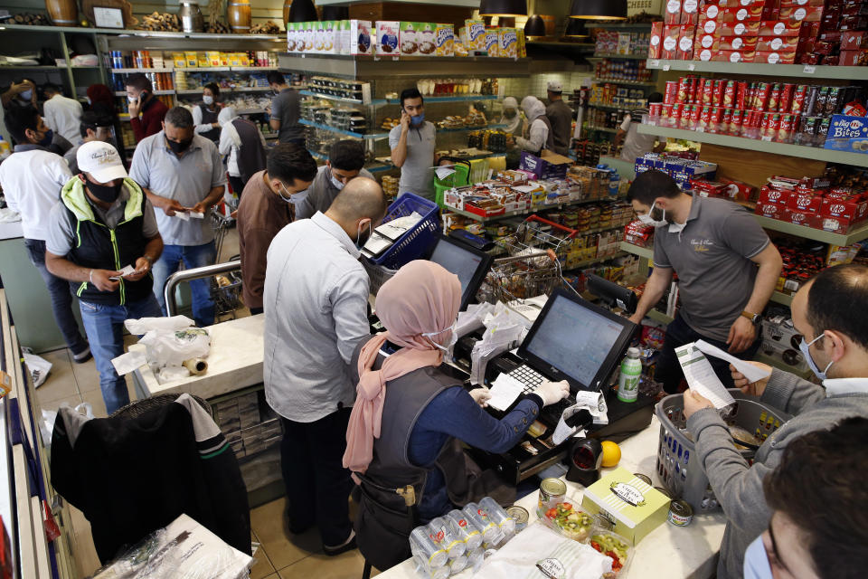 People shop at a supermarket as they begin to stock up on provisions, in Beirut, Lebanon, Wednesday, May 13, 2020. Lebanese rushed to food stores to stock up on vegetables and basic items, hours before the government was to reinstate a four-day nationwide lockdown on Wednesday, following a spike in reported coronavirus cases. (AP Photo/Bilal Hussein)