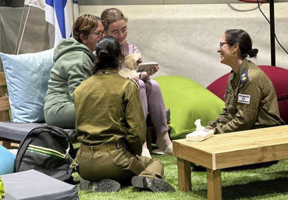 This handout photo provided by GPO shows Gabriela and Mia Leimberg, rear, talking with family from a meeting point in Israeli territory after being released by Hamas, Tuesday, Nov. 28, 2023. (GPO/Handout via AP)