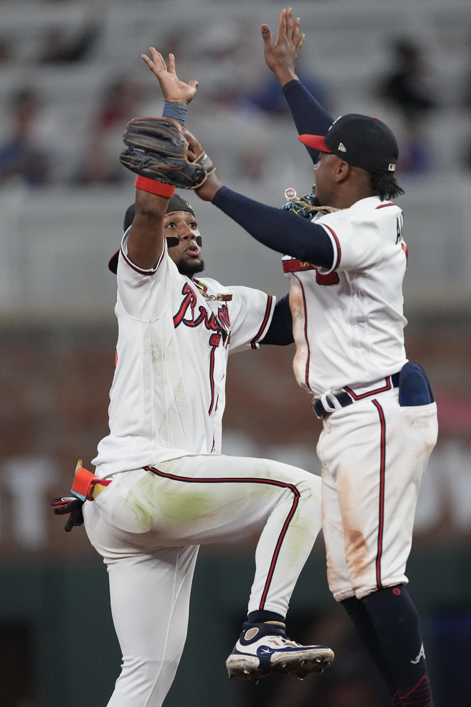 Atlanta Braves right fielder Ronald Acuna Jr. (13), left, and second baeman Ozzie Albies (1) celebrate after defeating the Chicago Cubs ina base ball game, Tuesday, Sept. 26, 2023, in Atlanta. (AP Photo/John Bazemore)