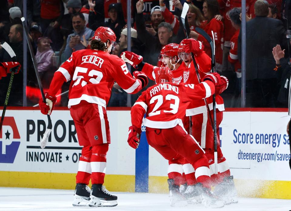 Detroit Red Wings right wing Patrick Kane, second from right, celebrates with teammates Moritz Seider (53), Lucas Raymond (23) and Andrew Copp after scoring in overtime against the Columbus Blue Jackets in an NHL hockey game Tuesday, March 19, 2024, in Detroit. (AP Photo/Duane Burleson)