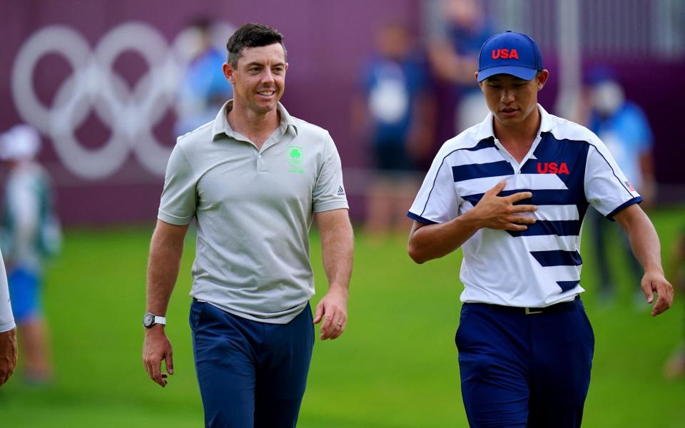 Ireland's Rory Mcilroy (L) and USA's Collin Morikawa (R) walk after hole out in round 1 of the mens golf individual stroke play during the Tokyo 2020 Olympic Games at the Kasumigaseki Country Club in Kawagoe on July 29, 2021 - GETTY IMAGES